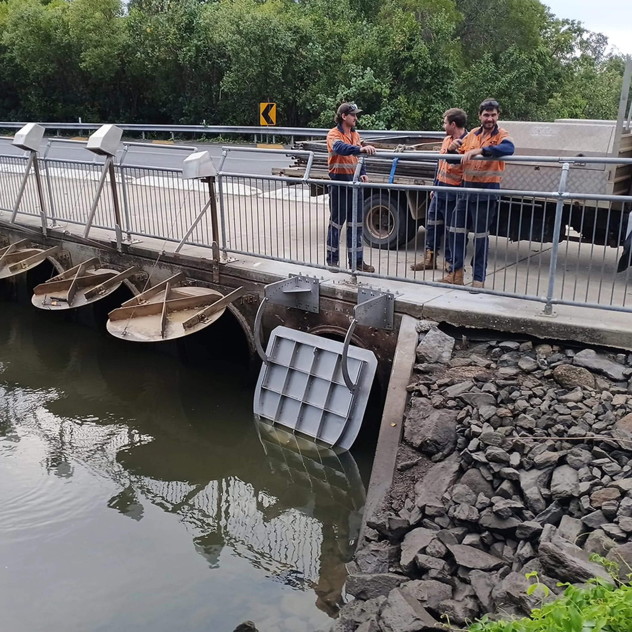 workers inspecting river flood gates